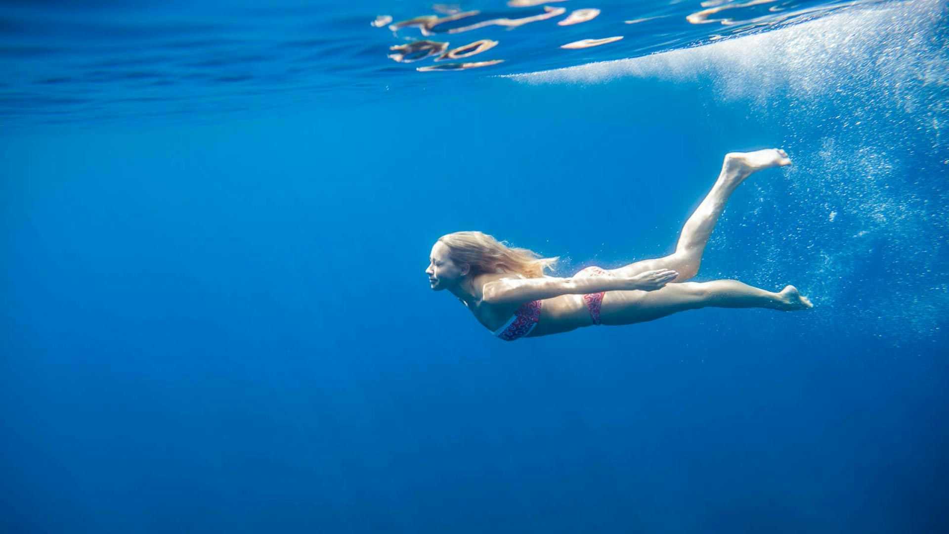 Woman swimming underwater in Greece 