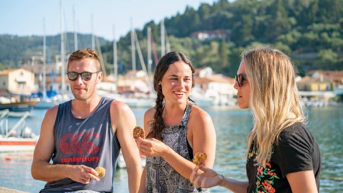 Group of people enjoy some Greek food on the waterfront in Lakka