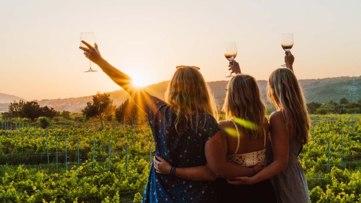 Three women drinking wine during sunset at Hora Farm in Stari Grad