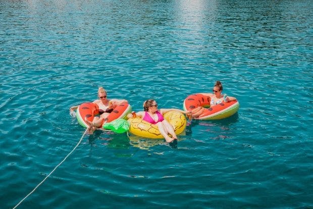 Guests floating on floaties with a drink