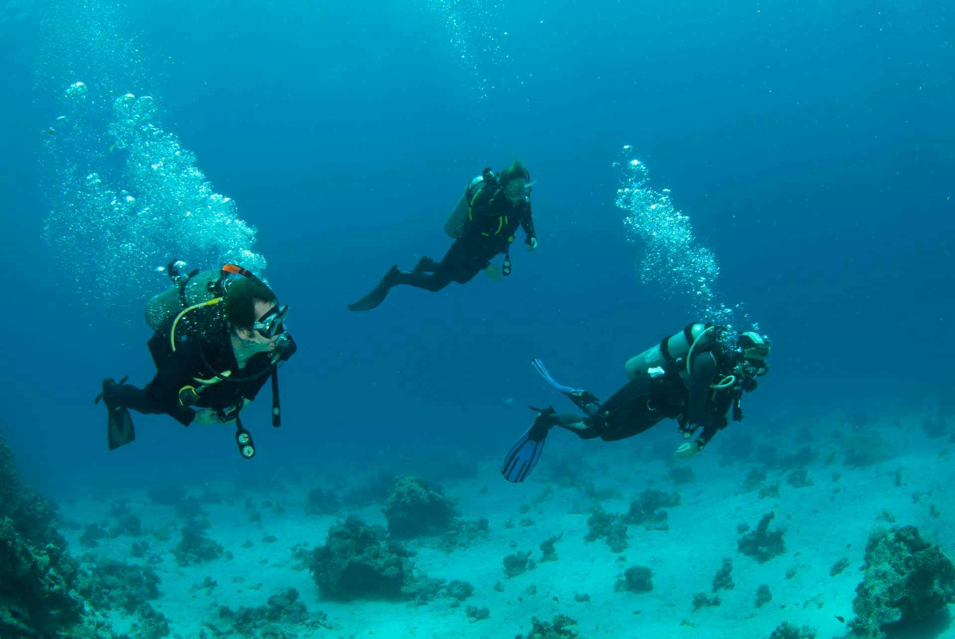 Three people scuba diving in Lakka