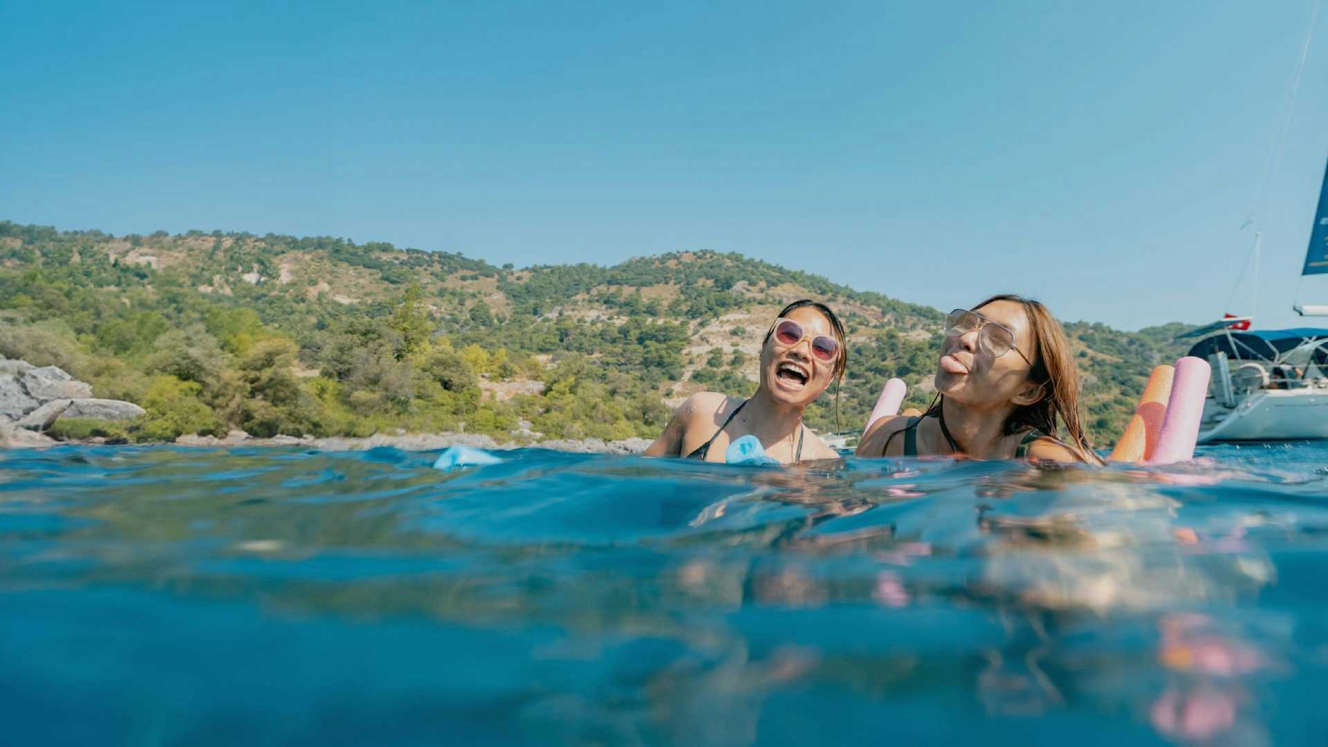 Photo of two females swimming in a beautiful Mediterranean bay.