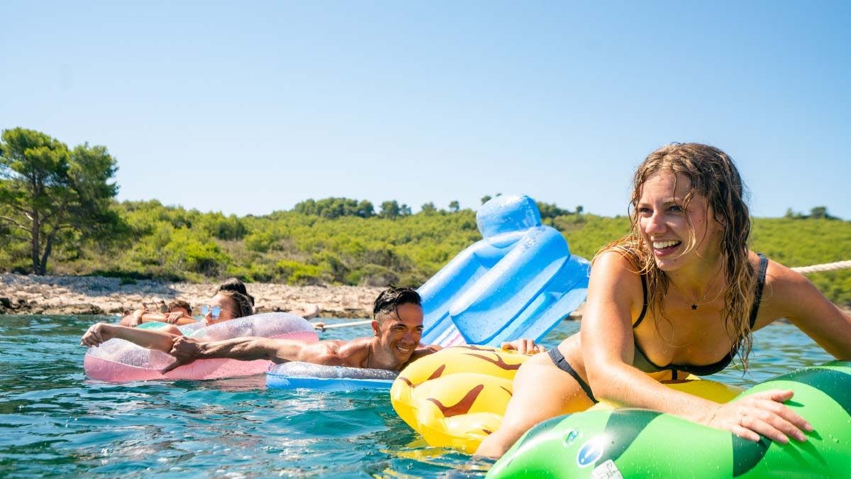 Group of people having fun on floaties in Croatia