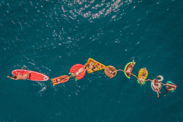 Photo above of people in the water on a line up of inflatables