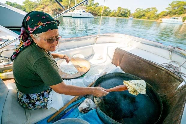 Woman making pancakes on a boat in Turkey
