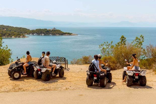 Photo of people on quad bikes in Spetses Greek Island overlooking a tranquil bay