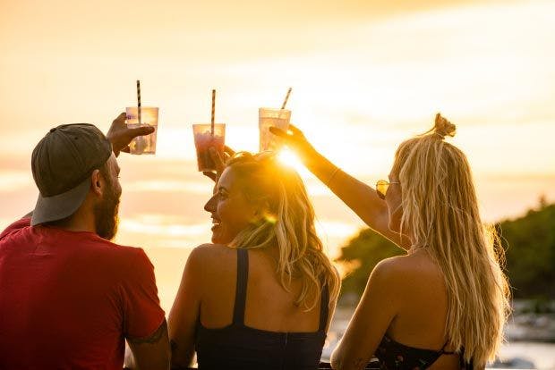 Image of friends having drinks at sunset