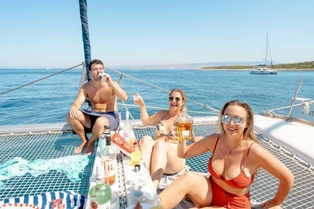 Friends cheers their drinks on a MedSailors yacht